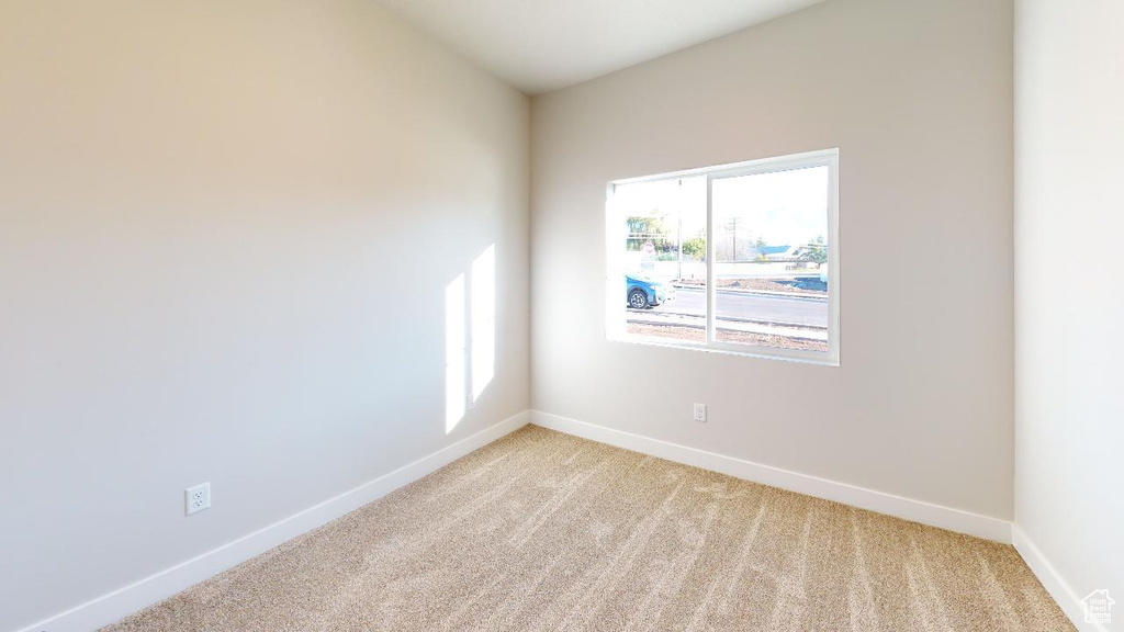 Empty room with baseboards and light carpet