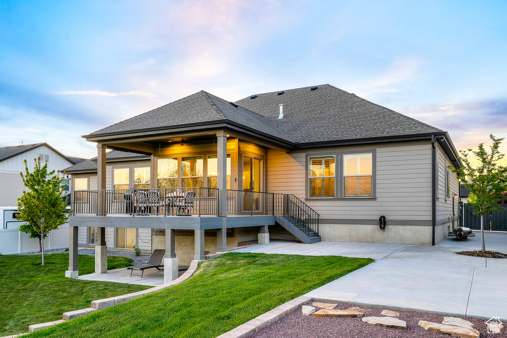 Rear view of house with a lawn, a patio area, stairs, a deck, and roof with shingles