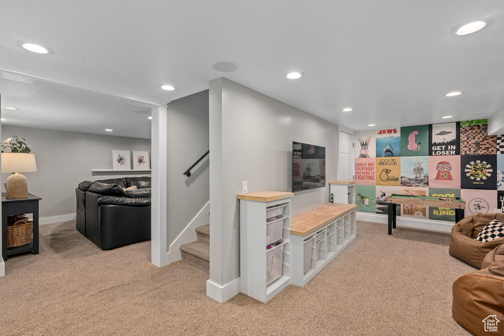 Living room with light colored carpet, baseboards, and recessed lighting