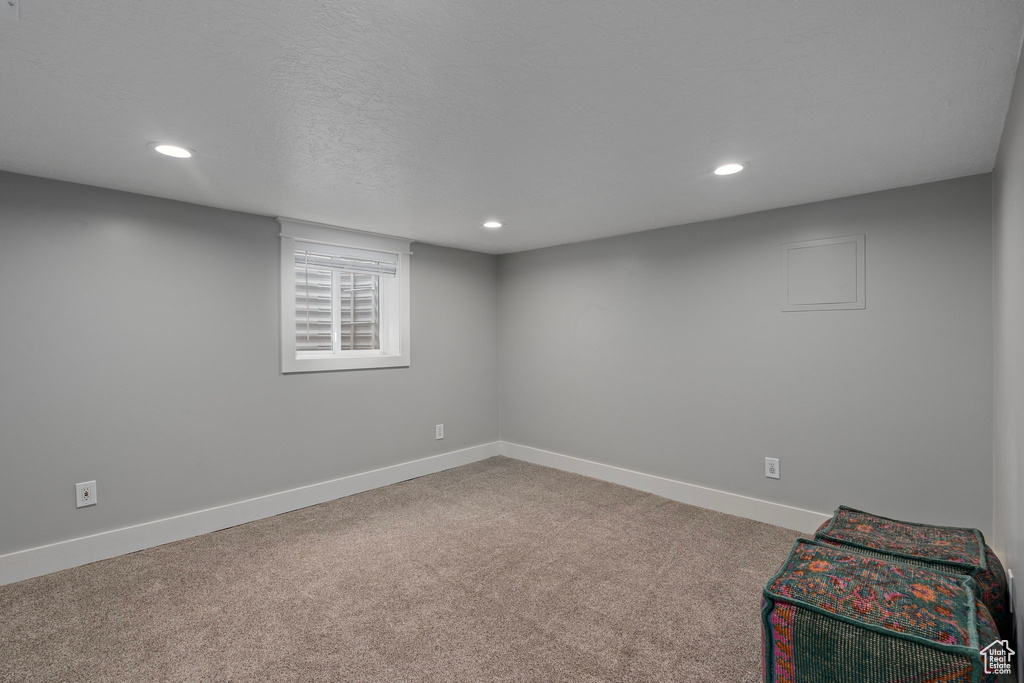 Basement with carpet floors, a textured ceiling, baseboards, and recessed lighting