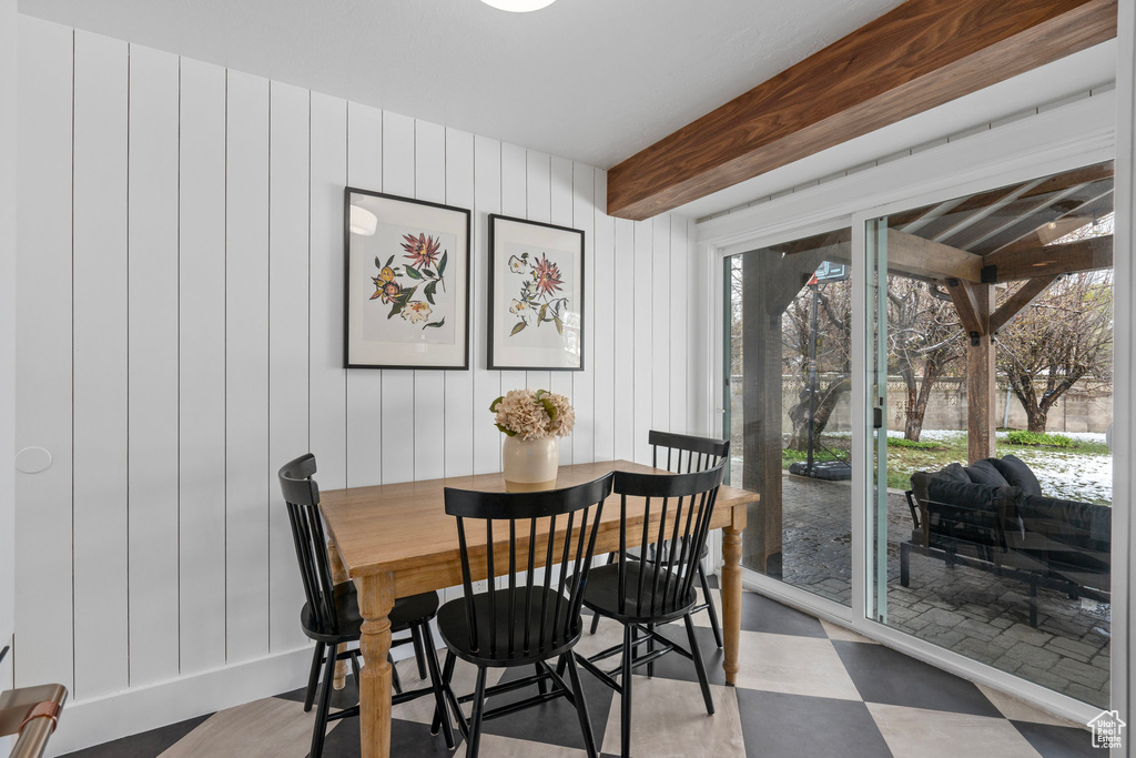 Dining space featuring tile patterned floors and beam ceiling