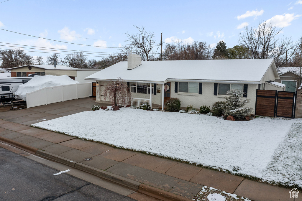 Single story home featuring a chimney, fence, a gate, and brick siding