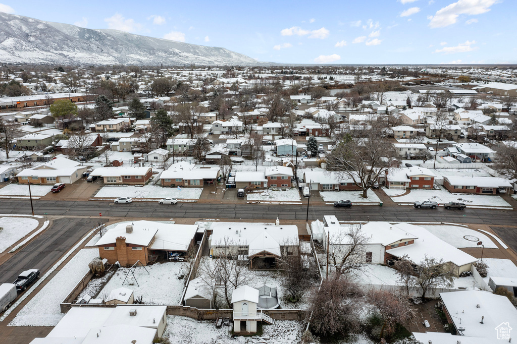 Snowy aerial view with a mountain view and a residential view