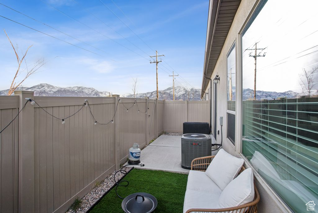 View of patio featuring a gate, fence, central AC, and a mountain view