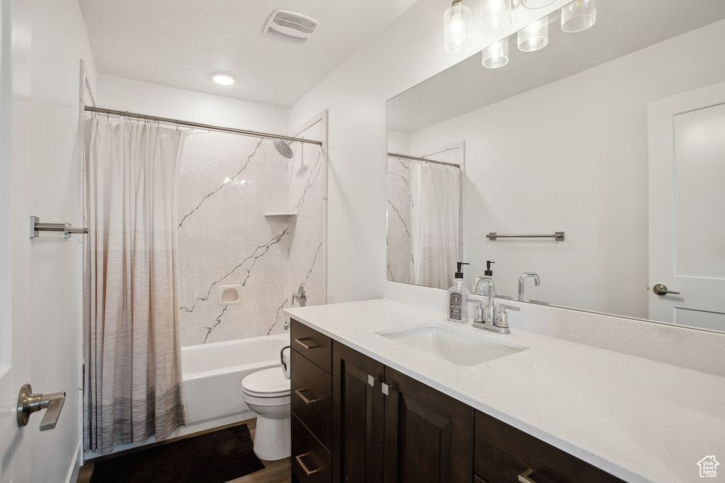 Full bathroom with visible vents, toilet, shower / tub combo with curtain, and vanity