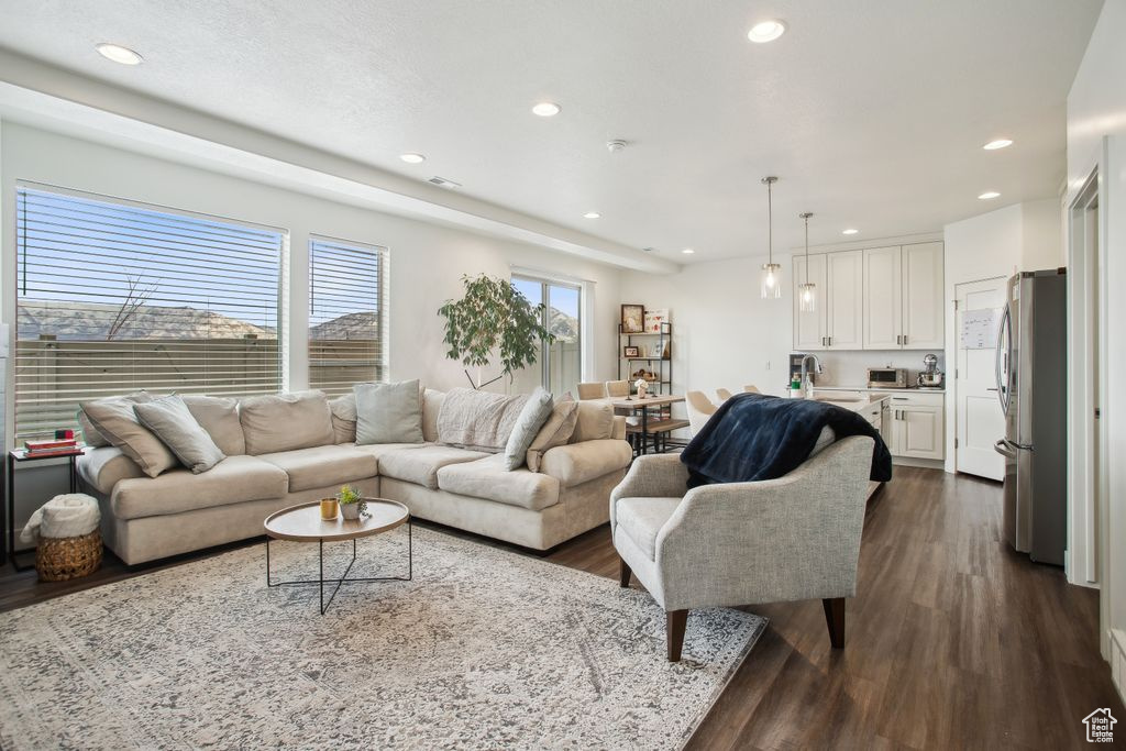 Living room with dark wood-type flooring and recessed lighting
