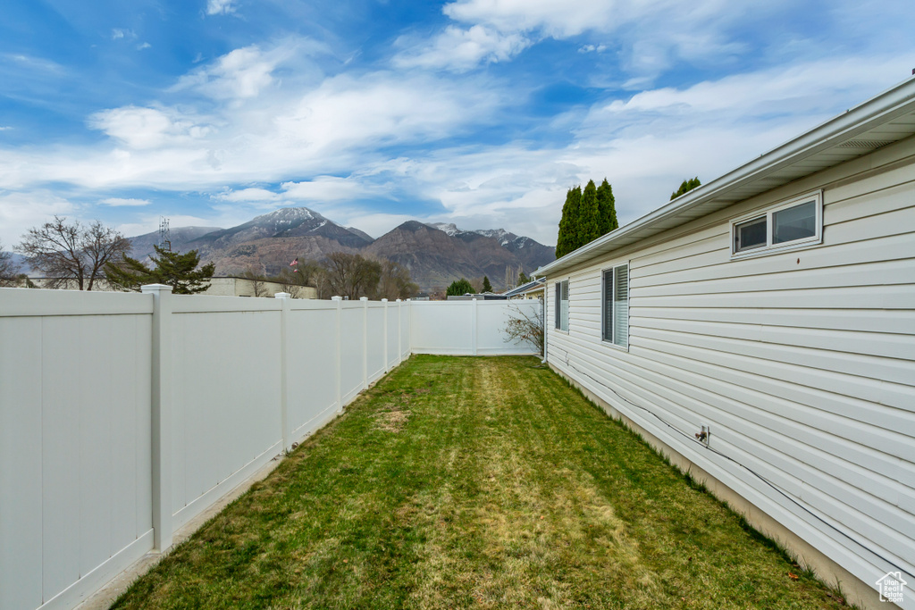 View of yard with a fenced backyard and a mountain view