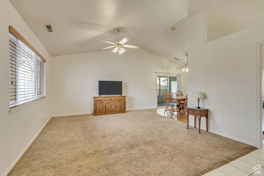 Interior space with a healthy amount of sunlight, a ceiling fan, and light carpet