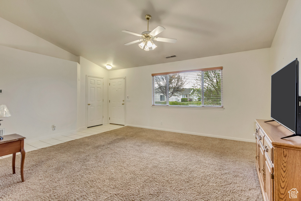 Living room with ceiling fan, lofted ceiling, light colored carpet, and visible vents