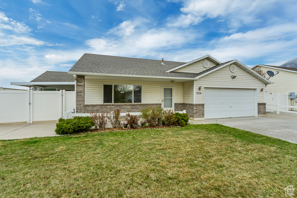 View of front of house with a gate, a garage, brick siding, and concrete driveway