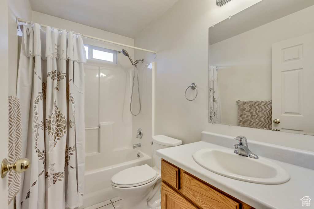 Full bath featuring toilet, vanity, tile patterned flooring, and shower / tub combo with curtain