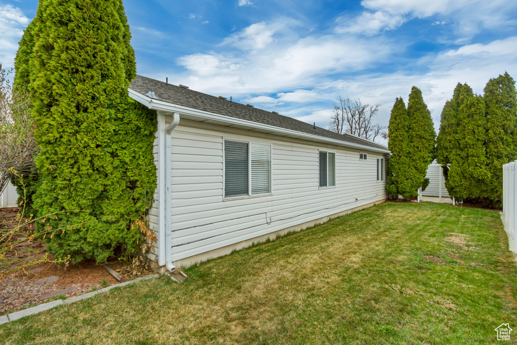 Back of house featuring a lawn and fence