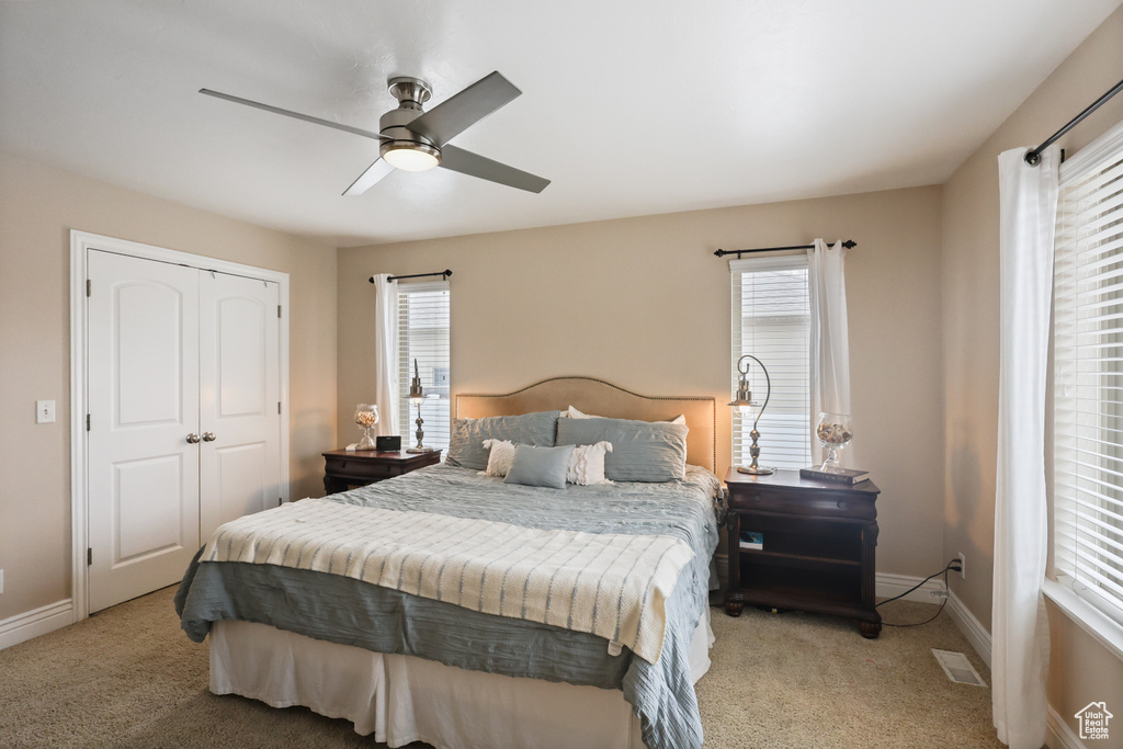 Bedroom featuring light colored carpet, visible vents, and baseboards