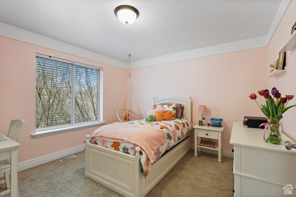 Bedroom featuring light carpet, baseboards, and visible vents