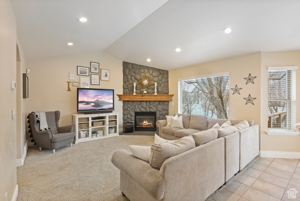 Living room with baseboards, recessed lighting, light carpet, a stone fireplace, and vaulted ceiling