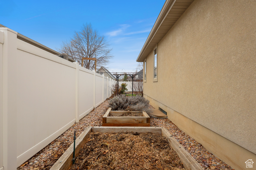 View of yard with fence and a garden