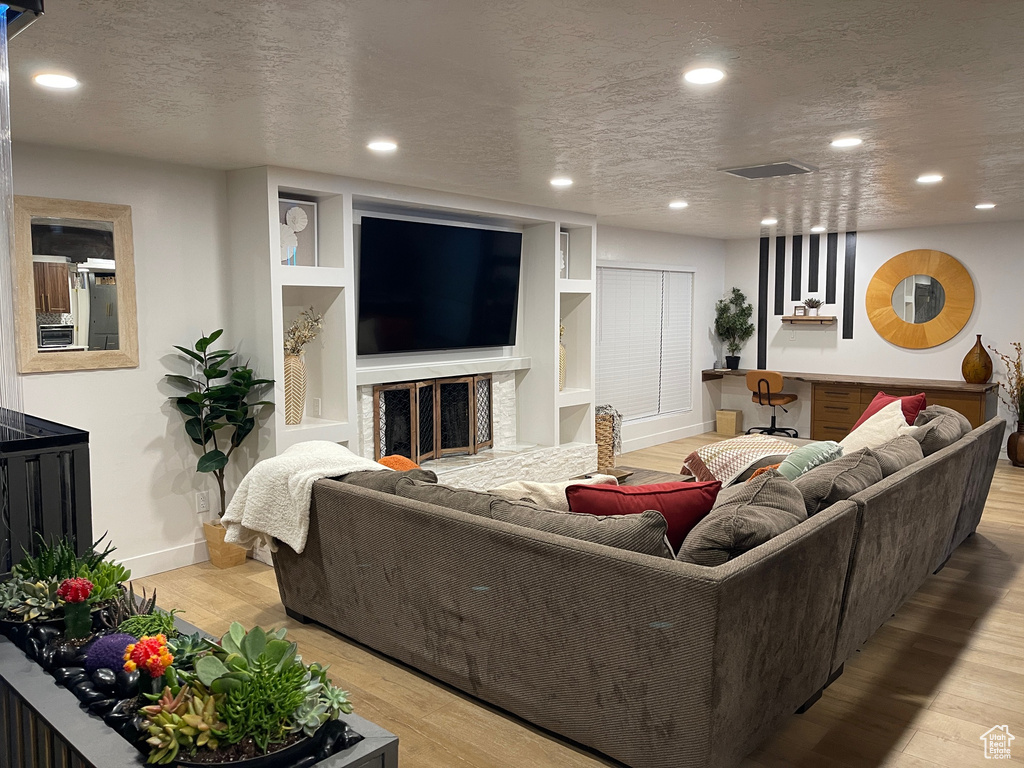 Living room with visible vents, wood finished floors, recessed lighting, and a textured ceiling