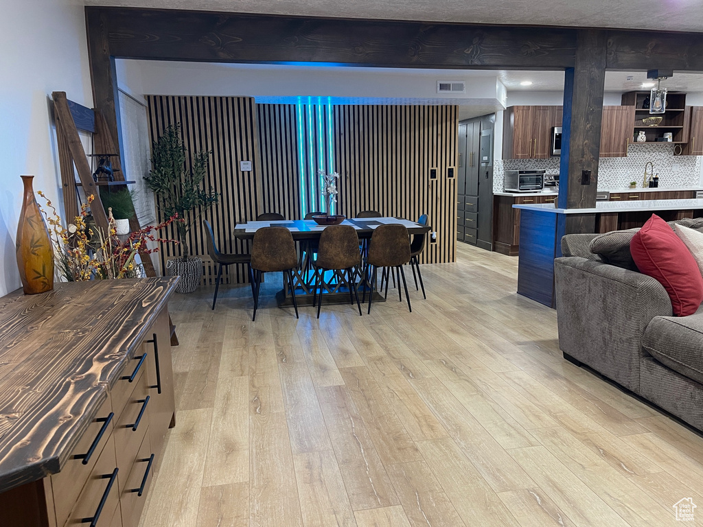 Dining room with light wood-style flooring and visible vents