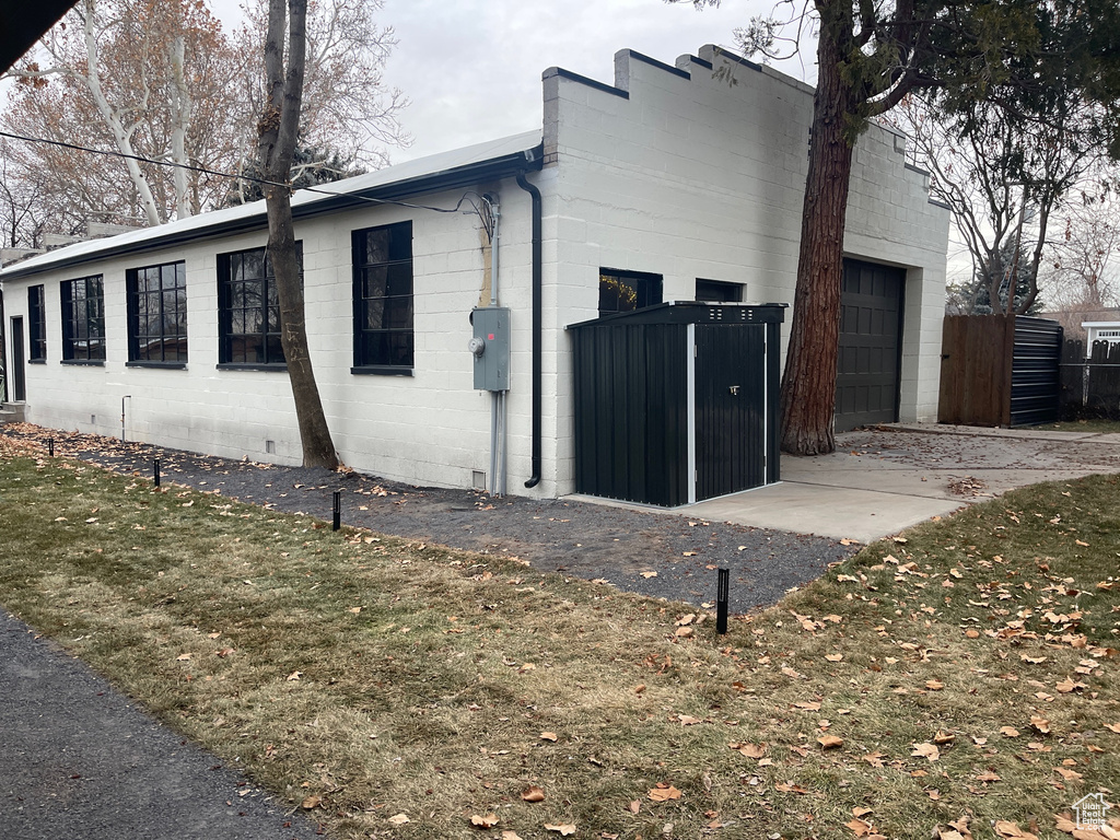View of home\'s exterior featuring fence, concrete block siding, an attached garage, and concrete driveway