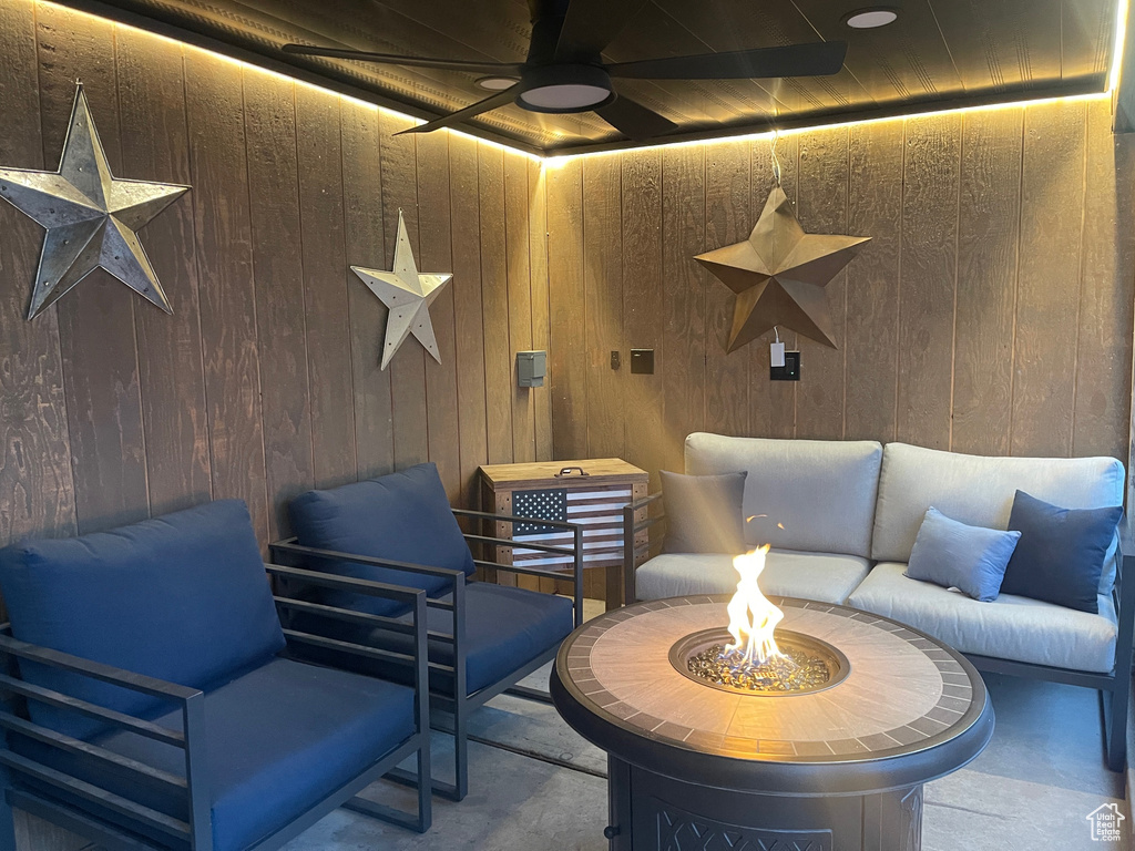 View of patio / terrace featuring a ceiling fan and an outdoor living space with a fire pit
