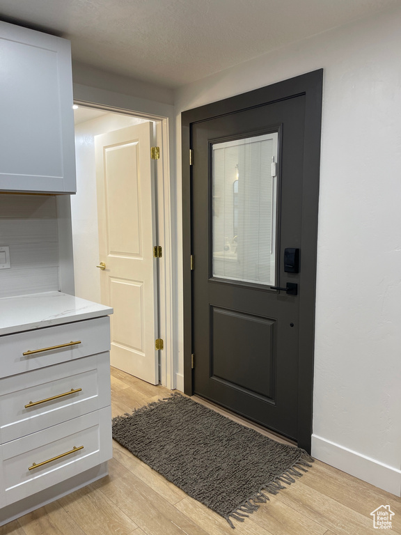 Entryway with baseboards and light wood-style flooring