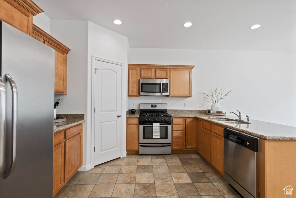 Kitchen with brown cabinets, recessed lighting, a sink, and stainless steel appliances