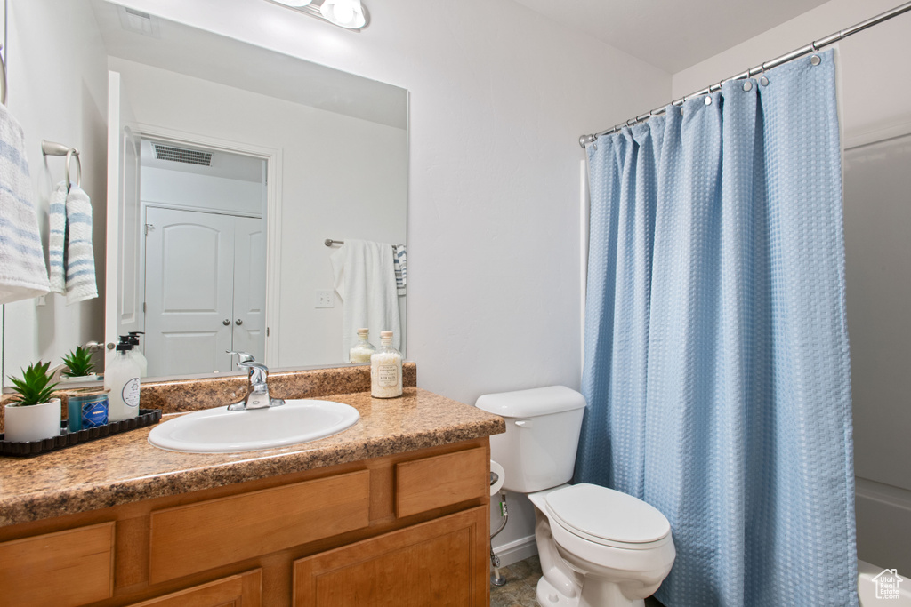 Full bathroom featuring toilet, vanity, curtained shower, and visible vents