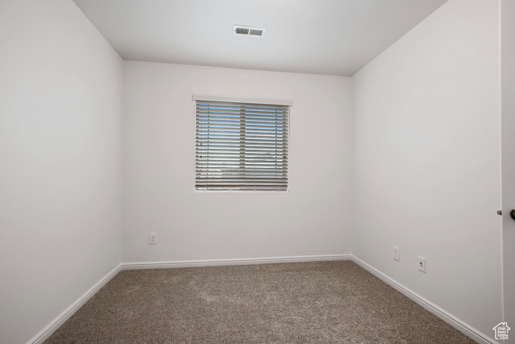 Carpeted spare room with baseboards and visible vents