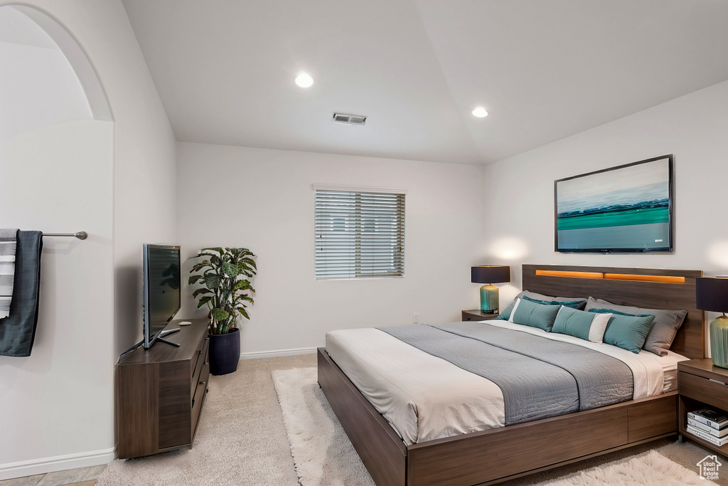 Bedroom with vaulted ceiling, light carpet, baseboards, visible vents, and recessed lighting