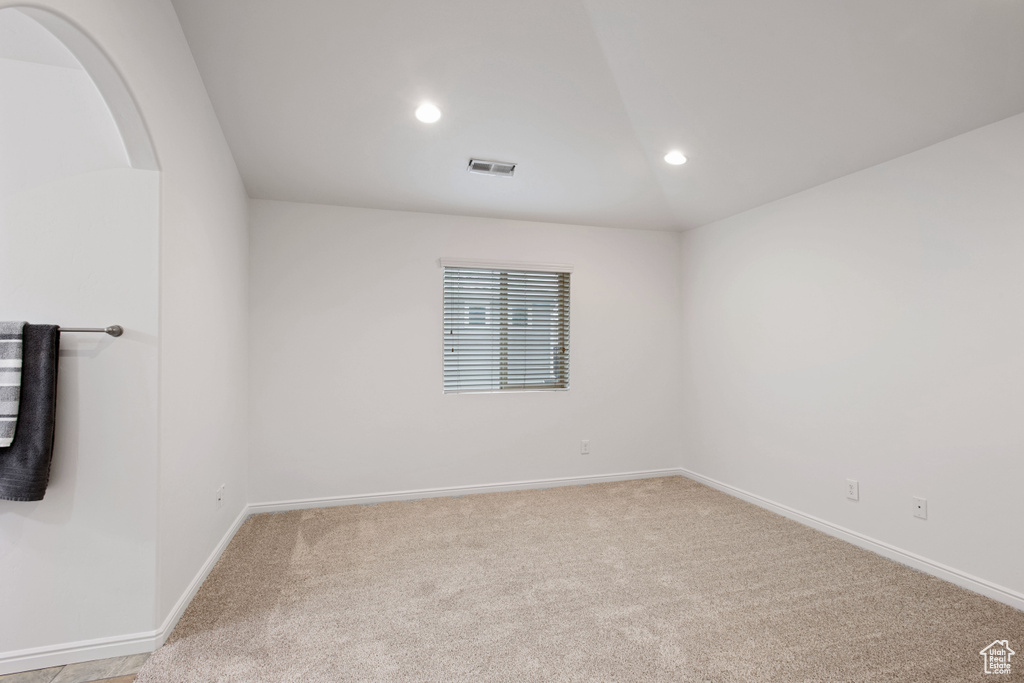 Carpeted spare room with baseboards, visible vents, and recessed lighting