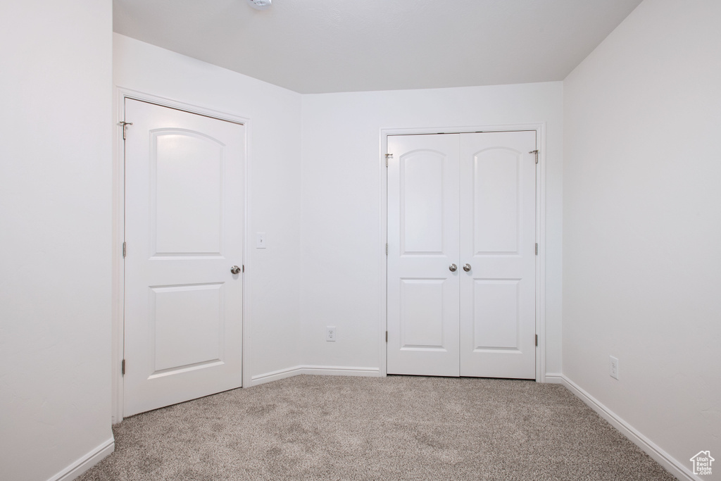 Unfurnished bedroom featuring baseboards and carpet flooring