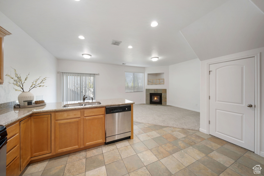 Kitchen featuring visible vents, dishwasher, a fireplace, recessed lighting, and a sink
