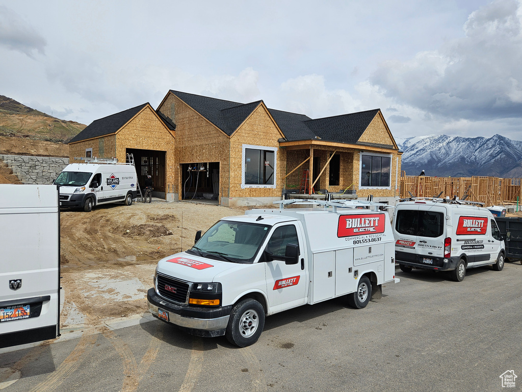 Property in mid-construction with brick siding, a mountain view, and fence