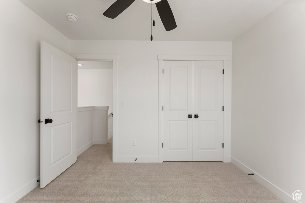 Unfurnished bedroom with light carpet, a closet, and ceiling fan