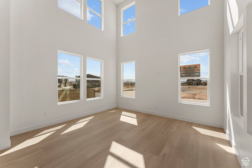 Spare room featuring light wood-style flooring and a high ceiling