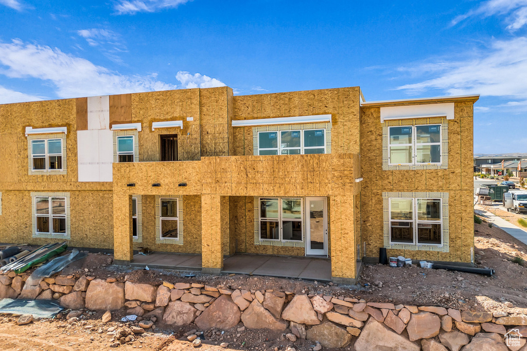 Rear view of property with stucco siding and a patio