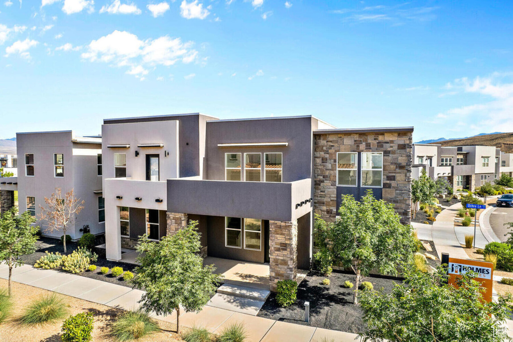 View of front of home featuring stone siding and stucco siding