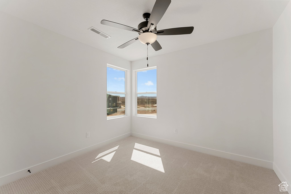 Empty room with light carpet and ceiling fan