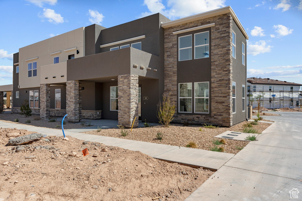 View of front of home featuring stucco siding and stone siding
