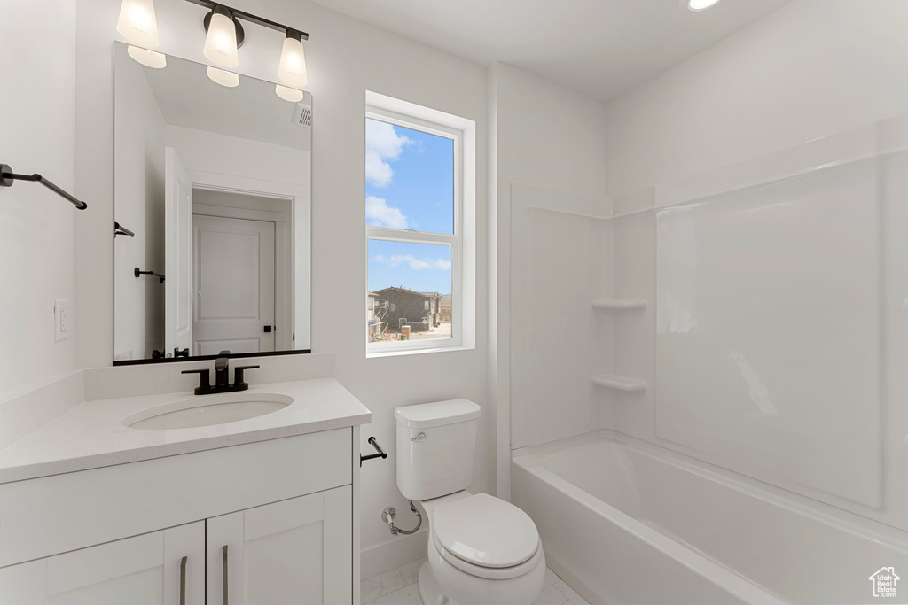 Bathroom featuring vanity, bathing tub / shower combination, and marble look tiles