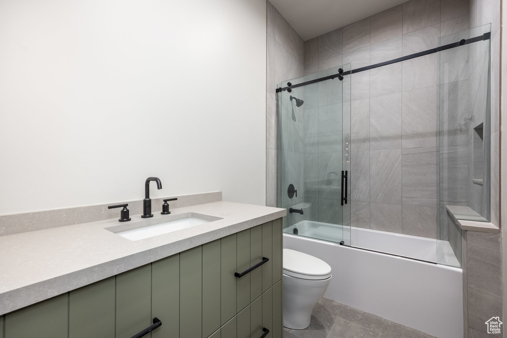 Full bathroom with combined bath / shower with glass door, toilet, and vanity