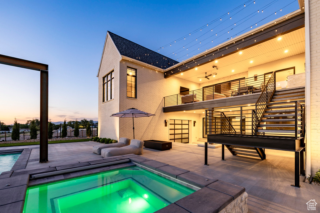 View of swimming pool with an in-ground hot tub, stairway, and a patio