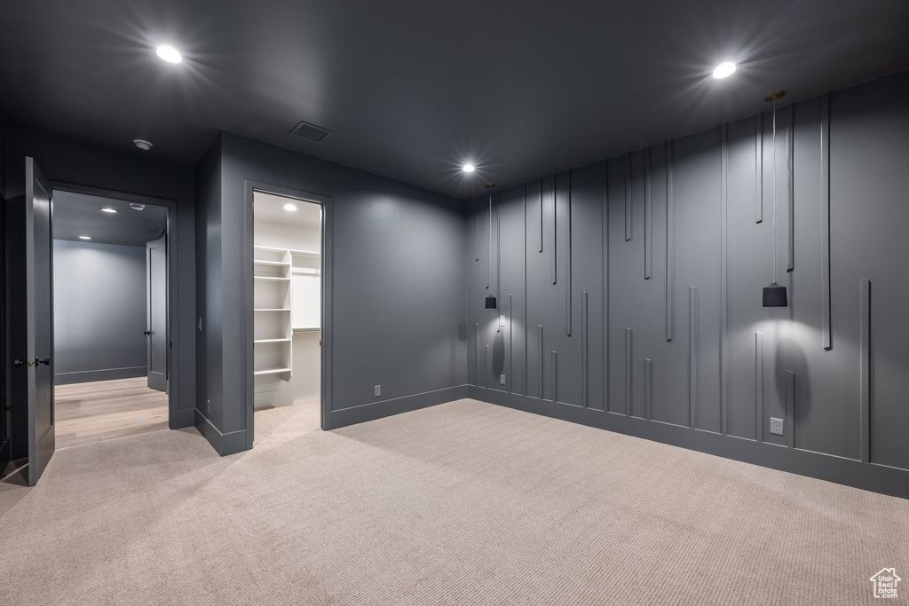 Carpeted empty room with baseboards, visible vents, and recessed lighting