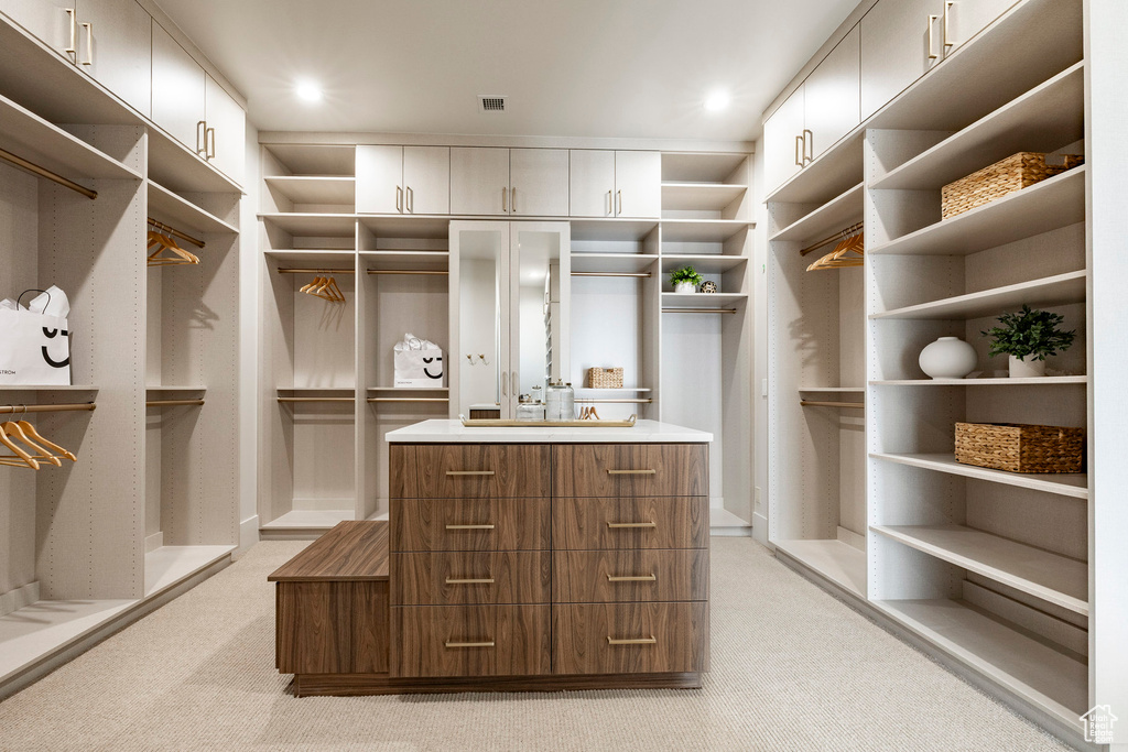 Walk in closet featuring light colored carpet