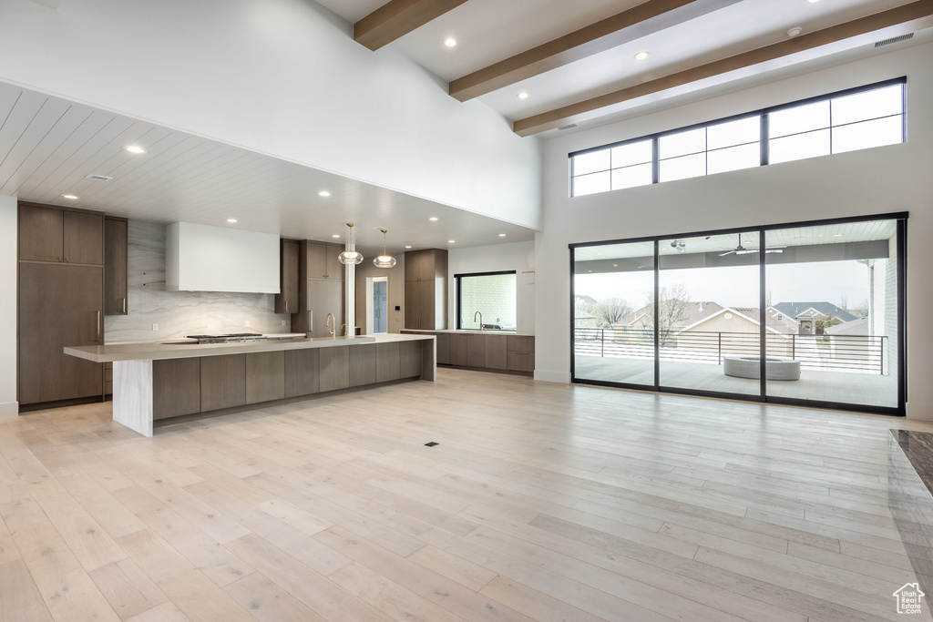 Kitchen with backsplash, light countertops, modern cabinets, and light wood-style floors
