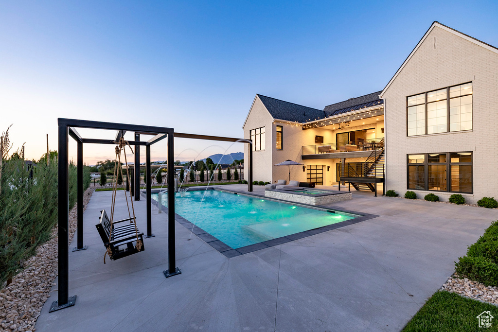 View of pool with a patio, a pool with connected hot tub, and stairs
