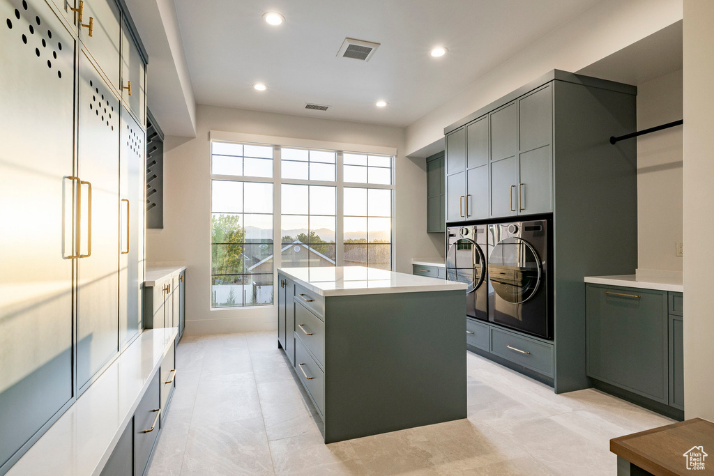 Laundry area featuring separate washer and dryer, cabinet space, and recessed lighting