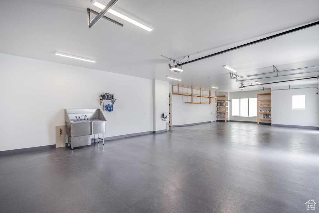 Garage with baseboards and a garage door opener