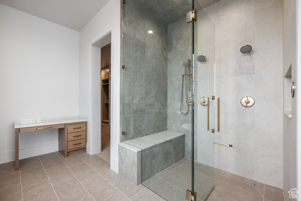 Full bathroom with a shower stall, tile patterned flooring, and a walk in closet