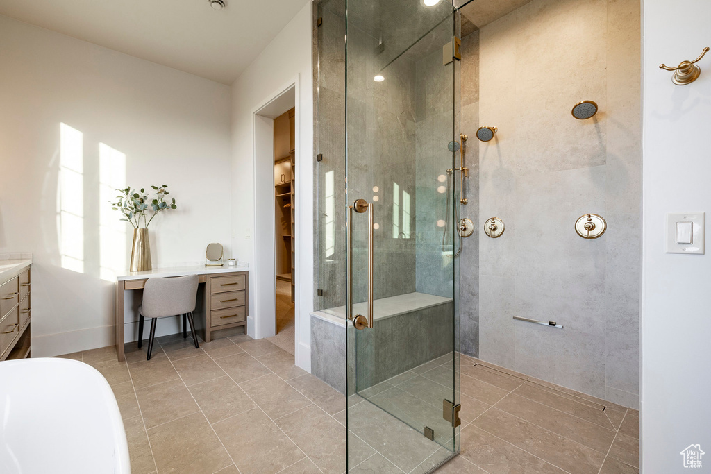Bathroom with vanity, a shower stall, tile patterned floors, and a freestanding bath